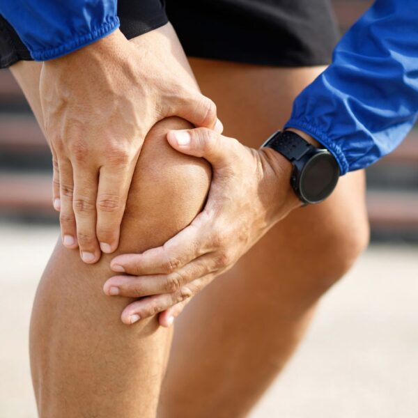 a person holding their knee in pain