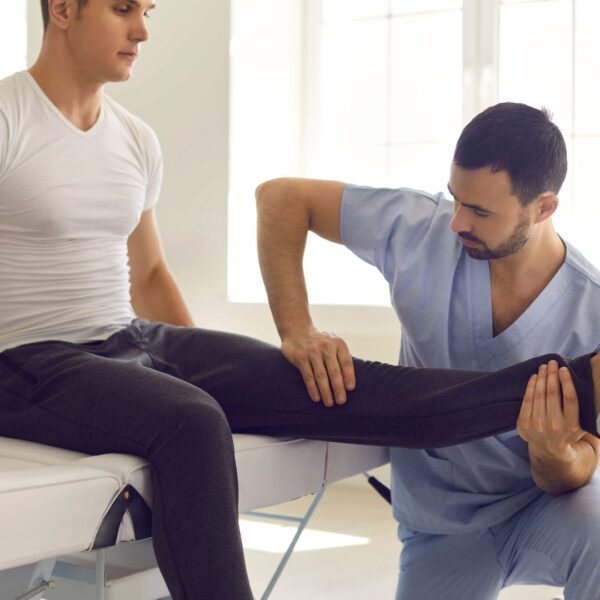 a chiropractor stretching out a mans leg